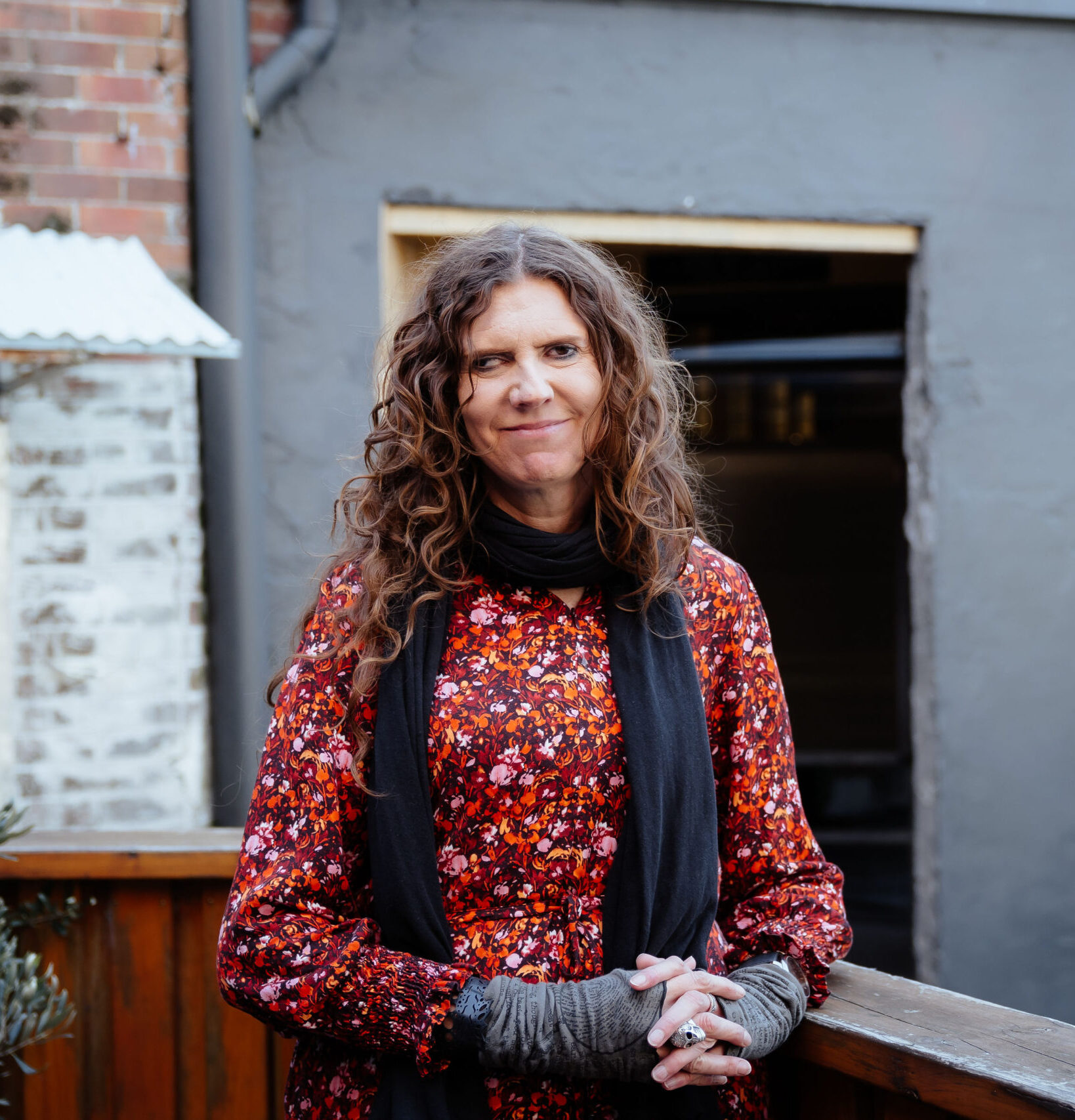 Image description: Woman smiling on an outdoor balcony