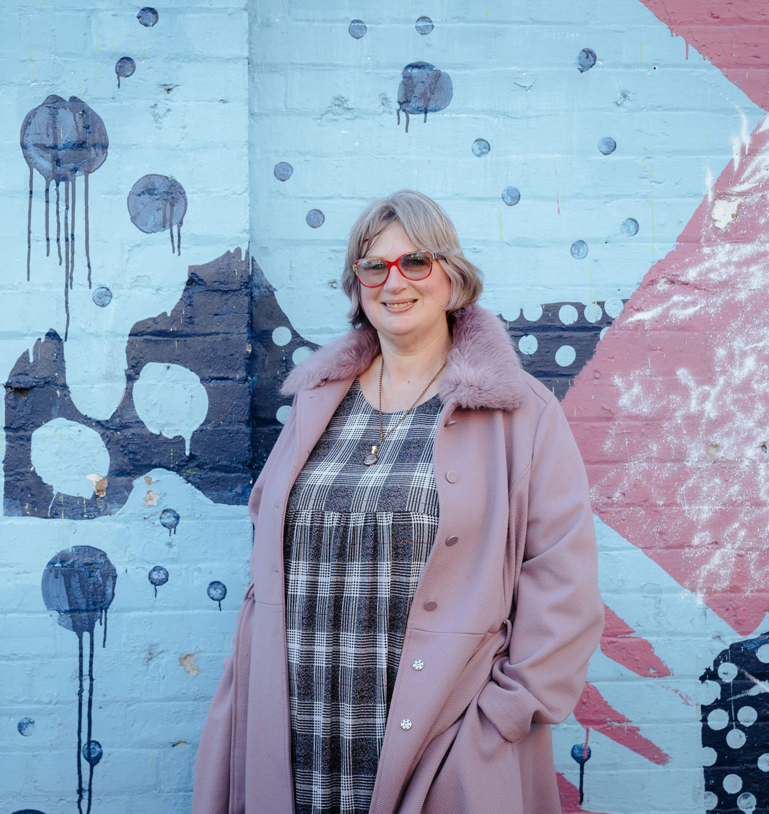Image description: Woman standing in front of mural