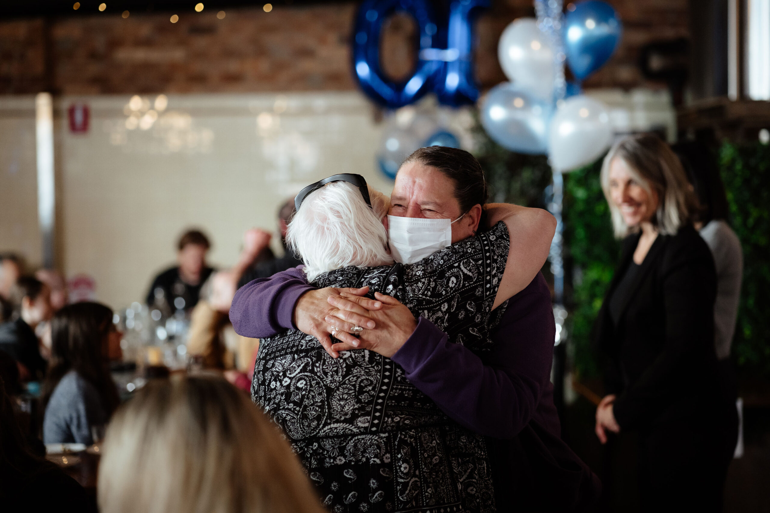 Image description: Two CDAH peers hugging indoors