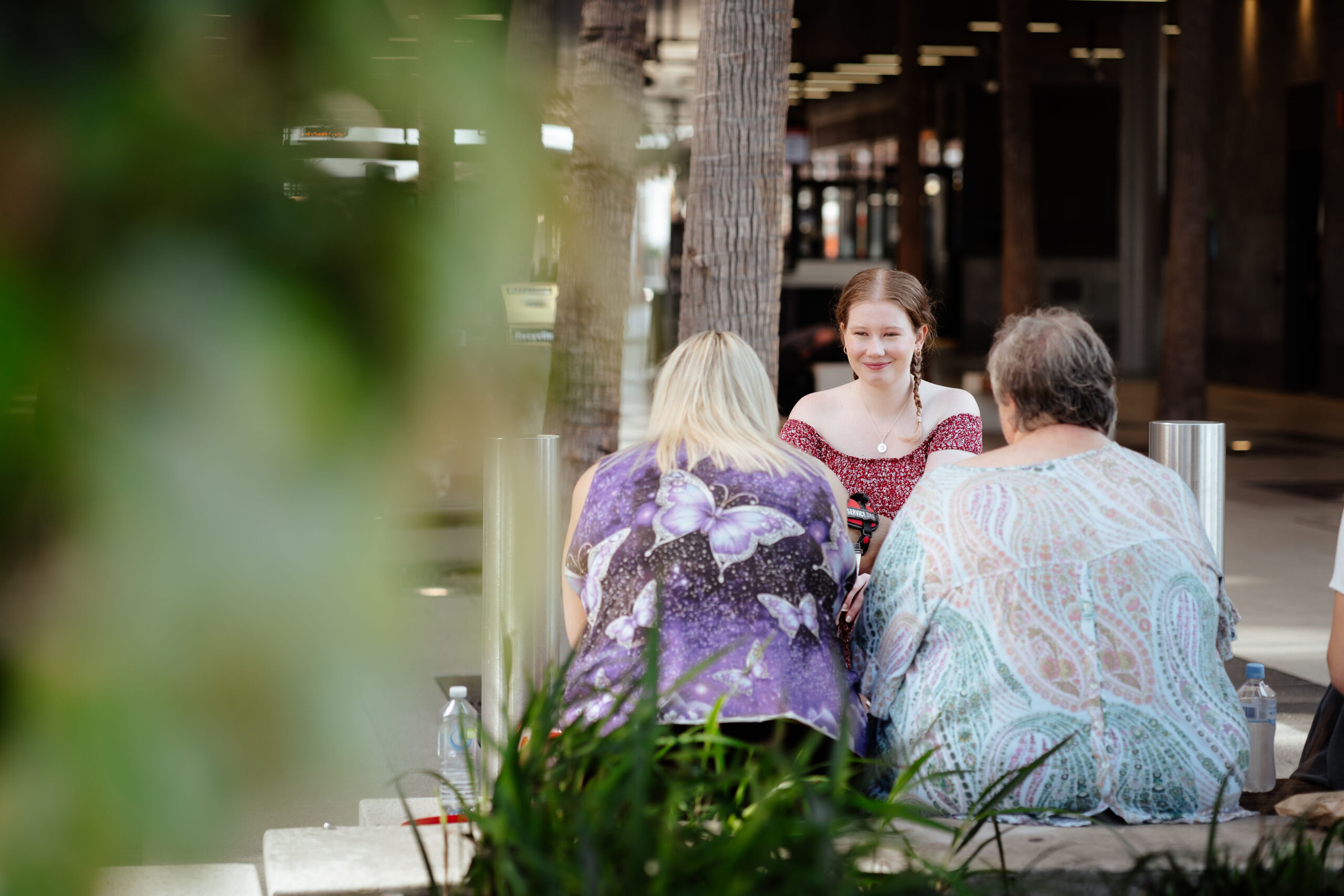 Image description: Three CDAH peers sitting at outdoor table