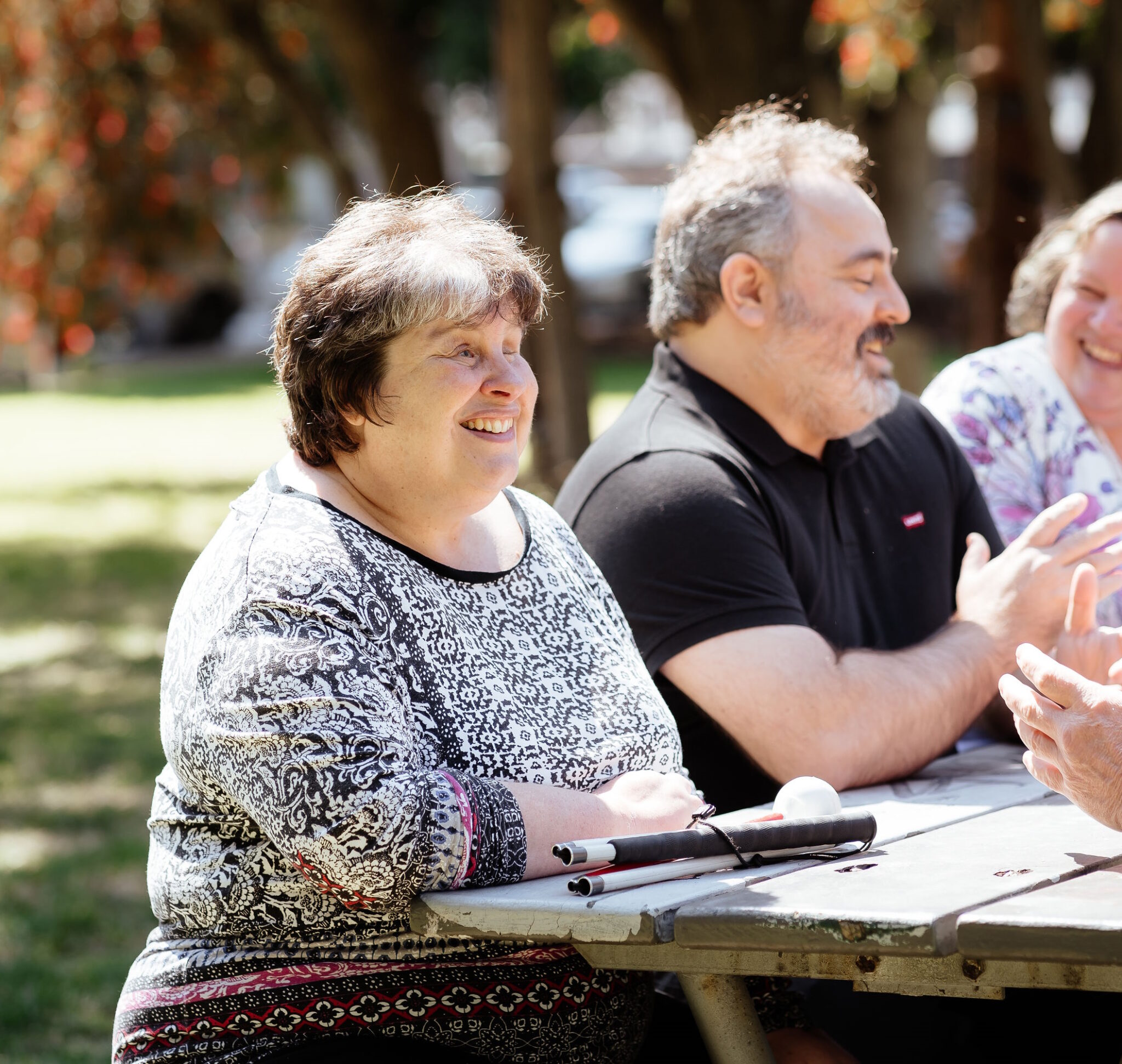 Image description: Photo of 3 CDAH peers sitting on a park bench