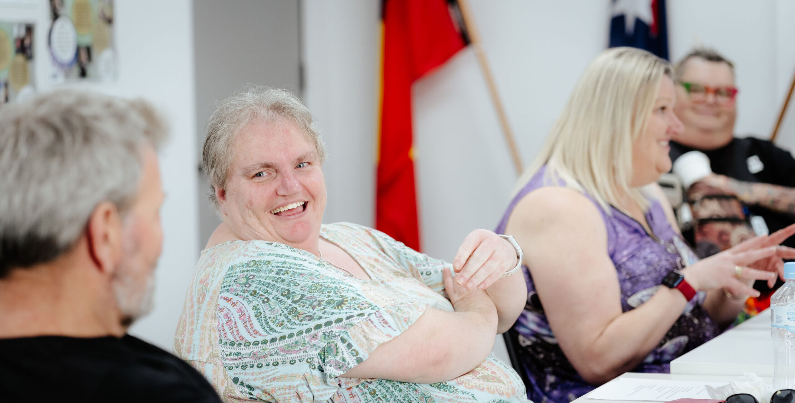 Image description: CDAH peers smiling around indoor table