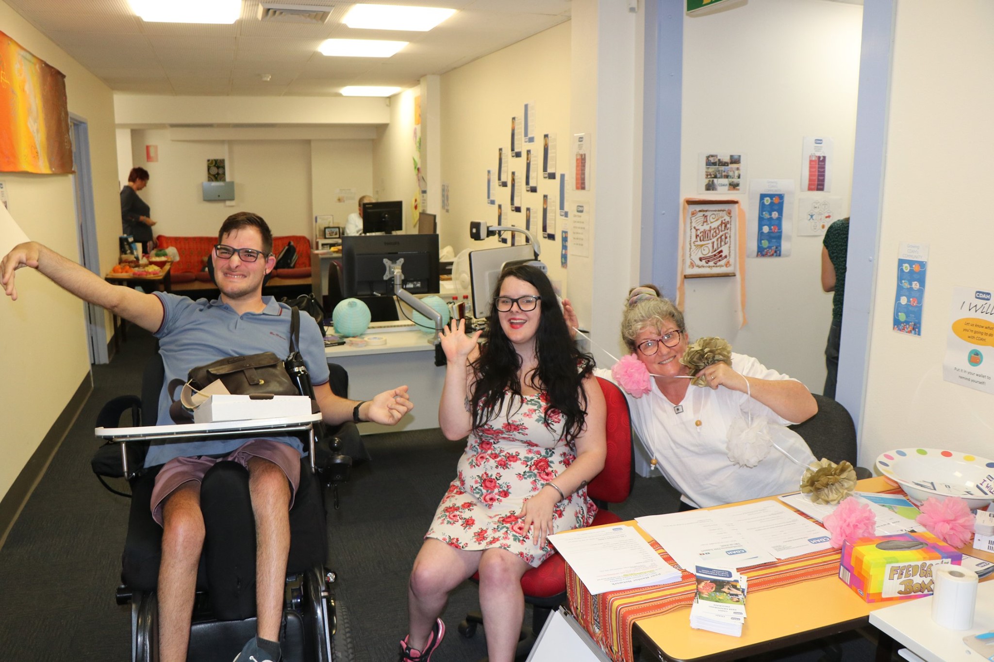 Image description: Three CDAH peers smiling and waving