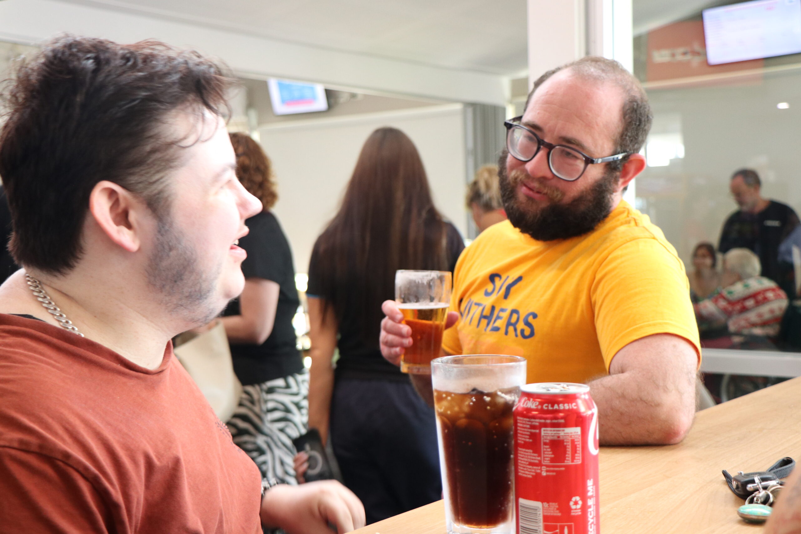 Image description: Two CDAH peers chatting and enjoying beverages