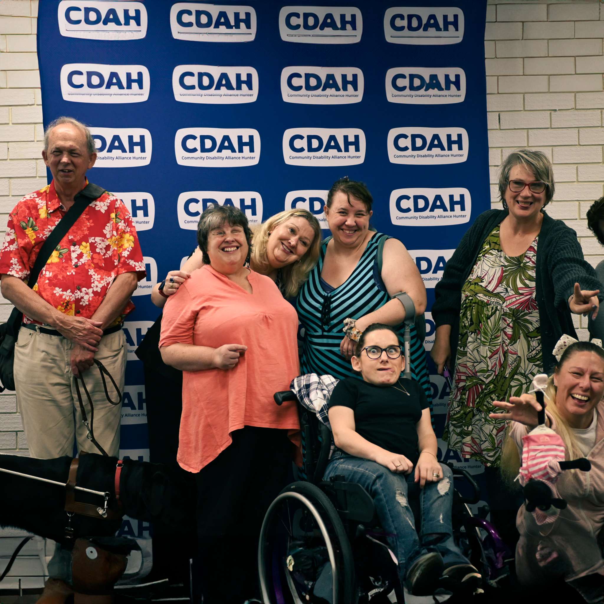 Image description: A group of CDAH peers posing in front of the CDAH banner